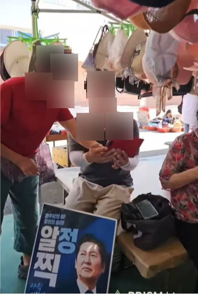 12일 순천 아랫장에서 청청유랑단 관계자가 한 권리당원의 휴대전화를 건네받아 투표 화면에 접속하는 등 대리투표 의혹을 낳은 정황이 담긴 장면. 유튜브 영상 캡처