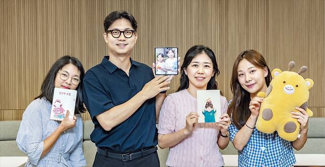 지난 6일 서울 서대문구 현대이지웰 사무실에서 직원들이 임산부 수첩과 자녀 사진 등을 들고 기념 촬영을 하고 있다. 현대이지웰은 직원들의 건의를 반영해 매년 가족 친화 제도를 확대하고 있다. /이태경 기자