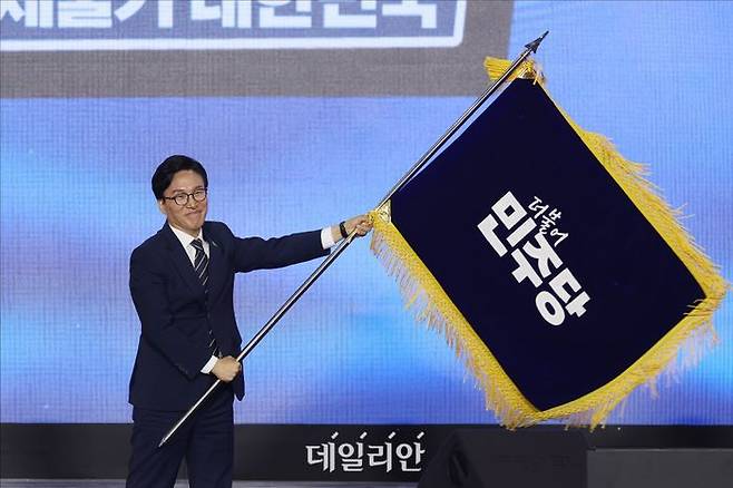 김민석 더불어민주당 신임 대표가 17일 오후 대전 유성구 DCC대전컨벤션센터 제2전시장에서 열린 더불어민주당 제3회 전국당원대회에서 당기를 흔들고 있다. ⓒ데일리안 홍금표 기자