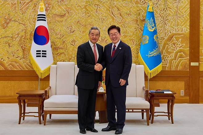 이재명 대통령이 20일 청와대에서 왕이 중국공산당 중앙정치국 위원 겸 외교부장과 접견에 앞서 악수하고 있다. 청와대 제공
