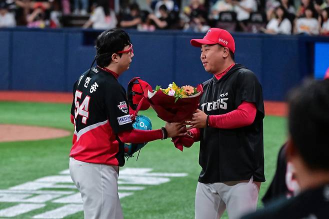 KIA 양현종이 21일 서울 고척 스카이돔에서 열린 2026 신한 SOL KBO리그 키움 히어로즈전에서 13시즌 연속 100이닝을 달성한 뒤 이범호 감독에게 축하 꽃다발을 받고 있다. (KIA 제공)