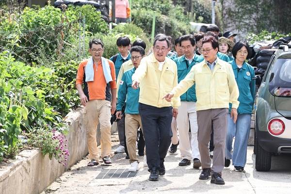 박완수 경남도지사와 강석주 통영시장이 통영 도천동 도로와 배수로 토사 유입 피해현장을 함께 둘러보며 복구 방안을 논의하고 있다. /경남도
