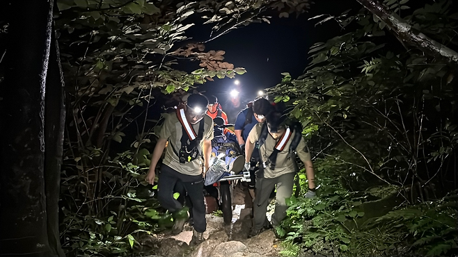 , 국립공원 특수 산악구조대와 119구조대로 꾸려진 합동구조대가 23일 설악산 출입 금지구역에서 부상을 입은 40대 A씨를 들것으로 옮기고 있다. 설악산국립공원사무소 제공