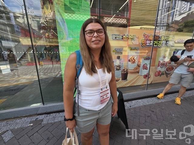 2026 대구세계마스터즈육상경기대회 포환던지기 종목에 출전한 남편을 응원하기 위해 볼리비아에서 대구를 찾은 갈라 씨가 24일 오후 대구 동성로의 올리브영 매장 앞에서 쇼핑백을 든 채 미소를 짓고 있다.
