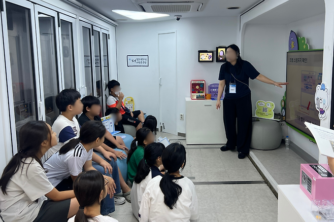 금융소외지역 아동들이 신한은행 이동점포 ‘뱅버드’에서 교육에 참여하는 모습. 굿네이버스 제공