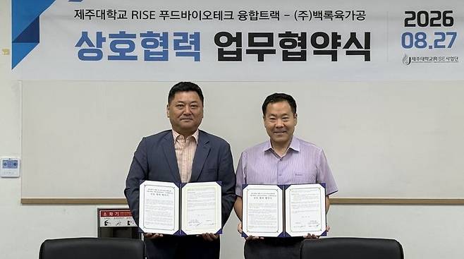 손영옥 제주대학교 RISE 푸드바이오테크 융합트랙 주임교수(오른쪽)와 문승택 ㈜백록육가공 대표가 27일 제주대 친환경농업연구소에서 푸드바이오·식육가공 분야 산학협력 업무협약을 체결한 뒤 협약서를 들어 보이고 있다. 양측은 제주 축산물의 가공기술과 제품개발 공동 연구, 학생 현장교육과 산업체 연계 프로젝트를 추진한다. /사진=제주대학교 제공