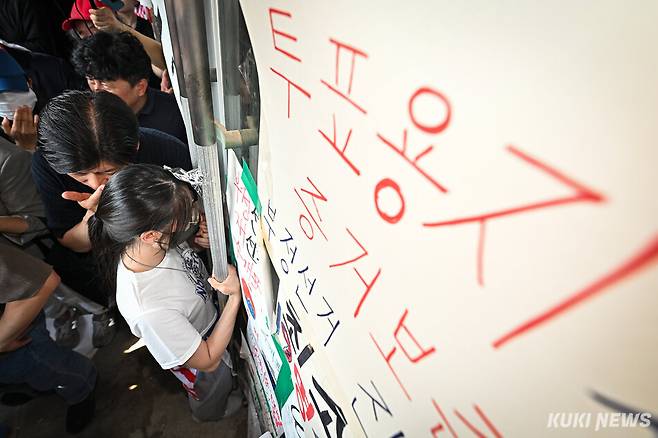 6·3 지방선거 투표용지 부족 사태로 '개표소 봉쇄 시위'가 이어지고 있는 16일 서울 송파구 올림픽공원 핸드볼경기장에서 한 시민이 진입을 막기 위해 출입문을 굳게 잡고 있다. 남동균 기자