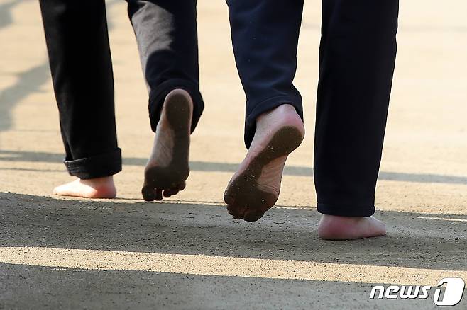 대구 수성못을 찾은 시민들이 산책로를 따라 맨발로 걷고 있다. ⓒ 뉴스1 공정식 기자