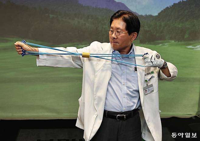 서경묵 센터장이 서울 강서구 부민병원에 마련된 골프 스윙 분석실에서 고무밴드를 사용해 스트레칭 제조를 하고 있다. 양회성 기자 yohan@donga.com