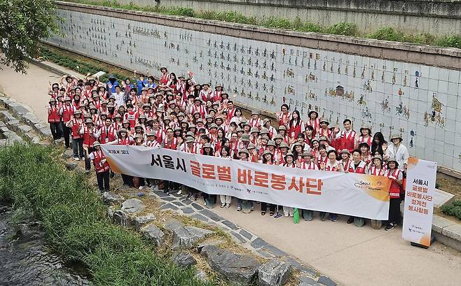 13일 서울시 글로벌 바로봉사단이 청계천에서 환경정비 활동을 마치고 기념촬영을 하고 있다. 서울시 제공