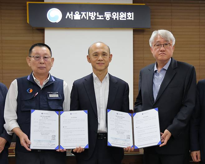 16일 서울 영등포구 서울지방노동위원회에서 열린 버스노조의 노동 쟁의 관련 분쟁에 대한 조정 회의에서 김정환 서울시버스운송조합 이사장(오른쪽 첫번째)과 박점곤 서울시버스노조 위원장(왼쪽 첫번째)이 조정안에 서명한 뒤 기념촬영을 하고 있다. 연합뉴스