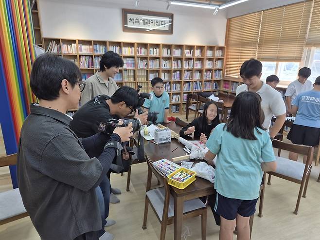 경남 함양군 휴천면 금반초에서 허수아비를 만들고 있는 아이들을 경남신문 취재팀이 카메라에 담고 있다. /김성후 선임기자