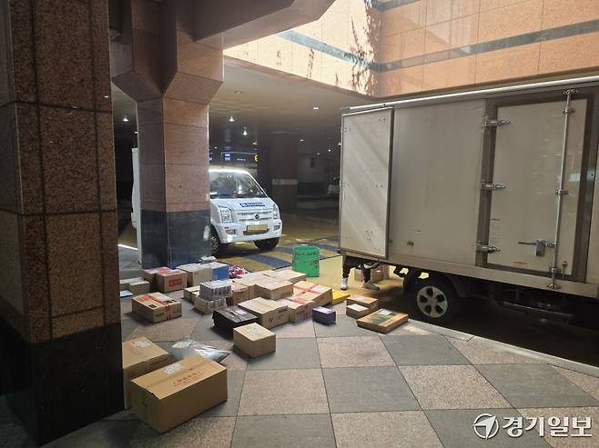 17일 성남시 분당구의 한 아파트에서 지하주차장에 진입하지 못한 택배차량이 입구에 멈춰 선 가운데, 기사들이 배송을 위해 택배 물품을 일일이 내려놓고 있다. 오종민기자