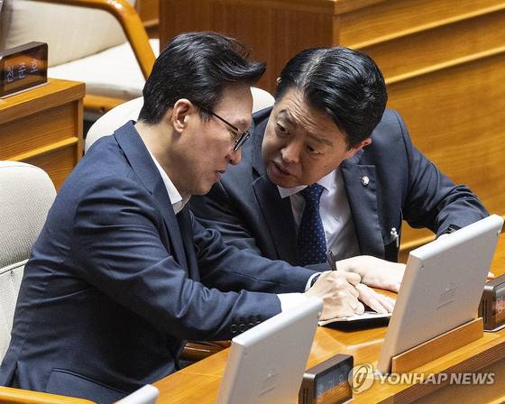더불어민주당 김민석 대표(왼쪽)가 11일 국회에서 열린 정기국회 제7차 본회의 경제 분야 대정부질문에 참석해 김영호 의원과 대화하다 수첩에 내용을 적고 있다. 〈사진=연합뉴스〉