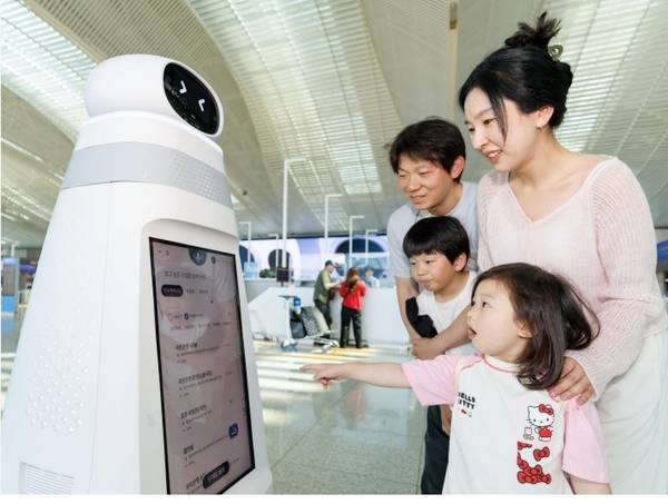 인천국제공항 제2여객터미널 3층 출국장에서 여객들이 안내·순찰 로봇에 도움을 받아 공항 정보를 확인하고 있다. /인천국제공항공사 제공