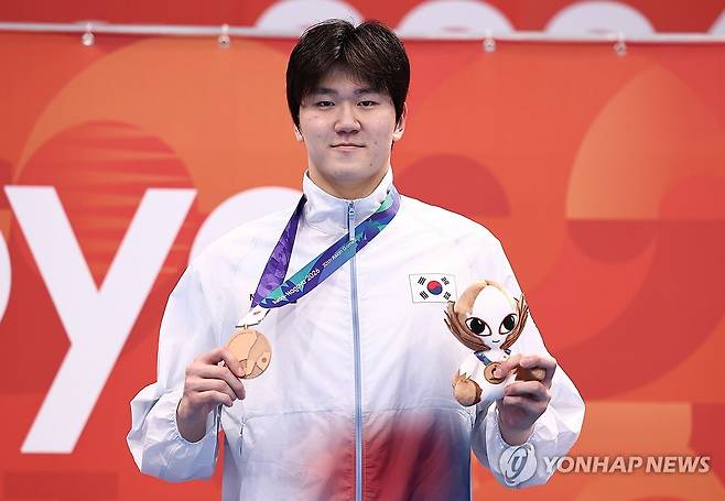 동메달 목에 건 윤지환 (도쿄=연합뉴스) 윤동진 기자 = 21일 도쿄 아쿠아틱스 센터에서 열린 2026 아이치·나고야 아시안게임 수영 남자 50m 개인 배영 결승. 동메달을 획득한 한국 윤지환이 메달을 들고 포즈를 취하고 있다. 2026.9.21 mon@yna.co.kr