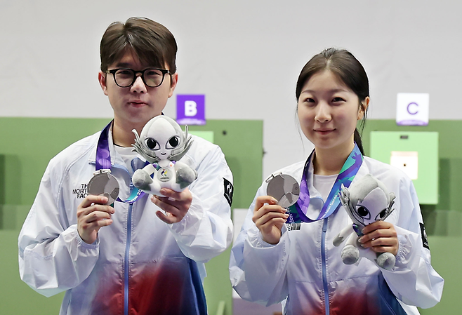 22일 일본 아이치현 종합 사격장에서 열린 2026 아이치·나고야 아시안게임 사격 10m 공기소총 혼성 단체전 시상식에서 은메달을 차지한 한국 반효진(오른쪽)과 박하준이 메달을 들어보이고 있다. 연합