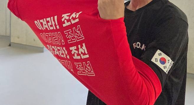 21일 한국과 북한의 아이치 나고야 아시안게임 여자 축구 경기에서 북한을 응원하던 조총련 관계자가 태극기가 붙은 티셔츠를 보여주고 있다. /이태동 기자