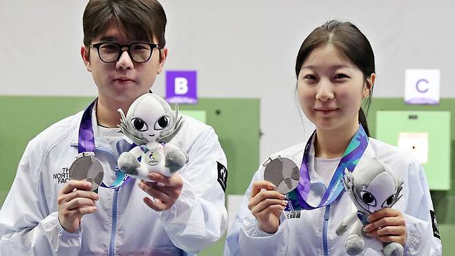 22일 일본 아이치현 종합 사격장에서 열린 2026 아이치·나고야 아시안게임 사격 10m 공기소총 혼성 단체전 시상식에서 은메달을 차지한 한국 반효진(오른쪽)과 박하준이 메달을 들어 보이고 있다.