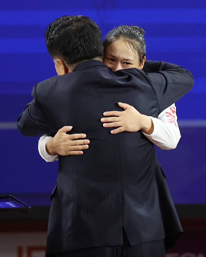 이날 일본 나고야 중소기업진흥회관에서 열린 2026 아이치·나고야 아시안게임 역도 여자 49㎏ 결승에서 금메달을 획득한 북한 리성금이 시상식에서 김일국 북한 체육상과 포옹하고 있다. / 사진 = 연합뉴스