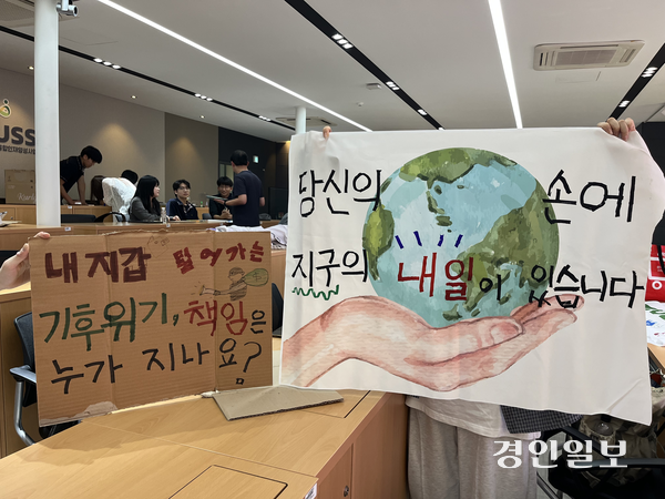 지난 16일 인천 미추홀구 인하대학교에서 ‘기후위기와 기후대응’ 수업을 들은 학생들이 인천녹색연합 활동가와 함께 만든 피켓을 들어보이고 있다. 2026.9.16 /송윤지기자 ssong@kyeongin.com