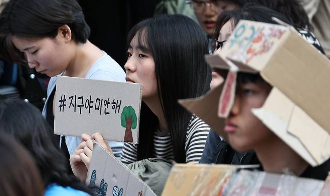 9·19 기후정의행진 참석자가 19일 서울 중구 태평로에서 '#지구야 미안해'라고 쓰인 손팻말을 들고 있다. 연합뉴스