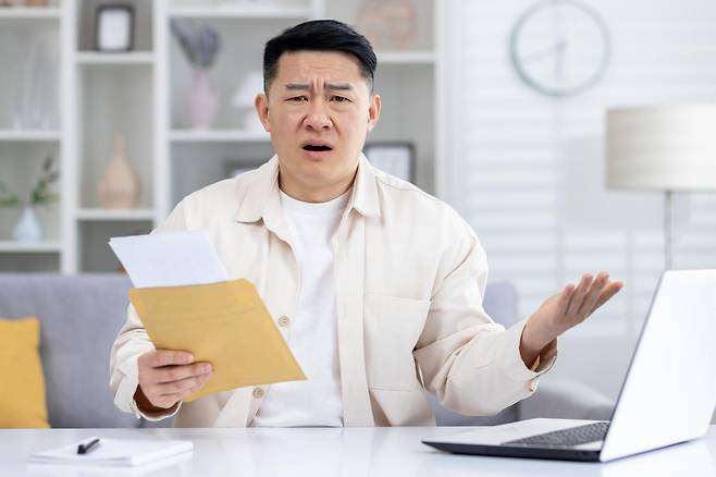 고지서를 확인하는 모습. 상속포기를 했더라도 응급의료법에 따른 미수금 대지급금은 일정한 가족에게 별도의 상환의무가 발생할 수 있다. 게티이미지뱅크