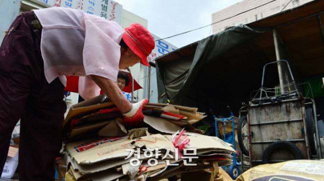 노인이 길거리에서 모은 폐지를 정리하고 있다. 정지윤 기자