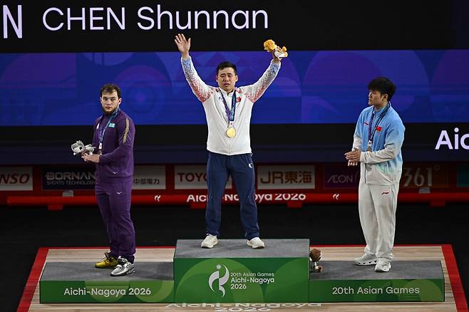 북한 로광렬이 28일 일본 나고야시 중소기업진흥회관에서 열린 2026 아이치·나고야 아시안게임 역도 남자 85㎏급 시상식에서 금메달을 목에 건 채 눈물을 흘리며 관중을 향해 손을 흔들고 있다. 로광렬은 용상 214㎏, 합계 379㎏의 세계신기록으로 우승했다. 나고야=하상윤 기자