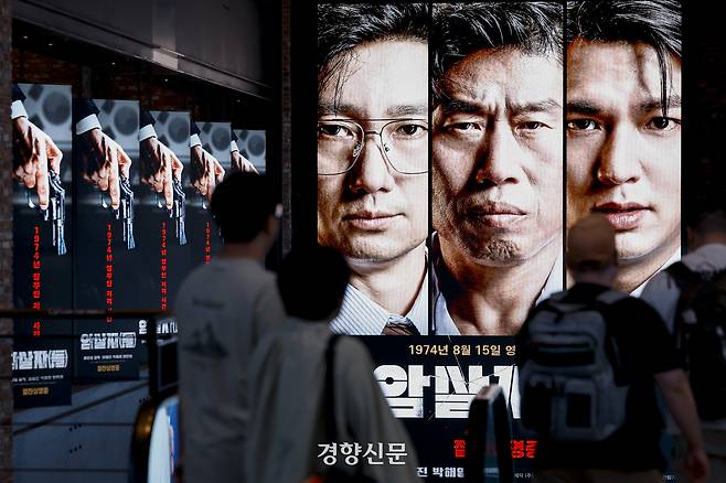 고(故) 육영수 여사 피격 사건을 다룬 허진호 감독의 영화 <암살자(들)>을 둘러싼 논란이 커지고 있는 가운데 지난 28일 한 시민이 서울의 한 극장에 걸린 영화 포스터 앞을 지나고 있다. 문재원 기자