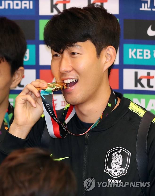 금메달 깨무는 손흥민 (영종도=연합뉴스) 김인철 기자 = 2018 자카르타-팔렘방 아시안게임에서 금메달을 획득하며 대회 2연패를 달성한 축구대표팀 손흥민이 3일 오전 인천국제공항으로 귀국한 뒤 해단식에서 금메달을 입에 물고 있다. 2018.9.3 yatoya@yna.co.kr