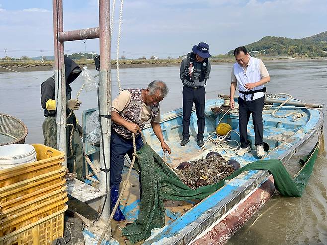 인천시 담당 공무원과 인하대 경기·인천씨그랜트센터 연구진이 12일 강화군 더리미포구 인근 해역에서 걷어 올린 그물에서 발견된 쓰레기를 분석하고 있다. /변성원 기자 bsw906@incheonilbo.com