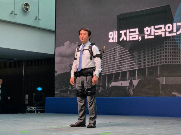 배충식 KAIST 총장이 공경철 교수가 개발한 웨어러블 로봇을 착용하고 무대에 섰다. /사진=박건희 기자