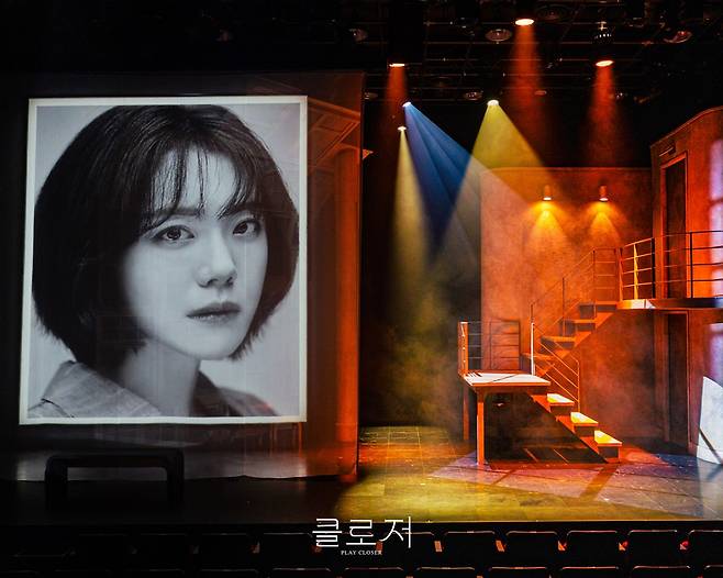 안나의 사진전에 걸린 앨리스(소주연)의 흑백 초상. 텅 빈 무대에 남겨진 앨리스의 얼굴이 묘한 쓸쓸함을 자아낸다. 사진제공|레드앤블루
