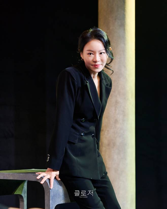 연극 ‘클로저’에서 안나 역의 리사. 검은 정장 차림에 옅은 미소를 머금은 모습에서 안나 특유의 우아함과 차분함이 느껴진다. 사진제공|레드앤블루