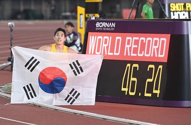 장민호(안양시청)가 장애인아시안게임 육상 남자 400m(T13) 결승 경기에서 압도적인 레이스 끝에 46초24의 세계 신기록(WR)을 세운 후 태극기를 펼쳐들고 환호하고 있다. 안양시청 육상팀 제공.