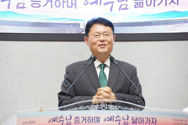 김형근 목사가 지난 23일 금요철야예배에서 최복이 이사장을 소개하고 있다. 김 목사는 “고난 속에서도 뜻을 구하며 일터 교회를 세워온 최복이 이사장의 간증이 우리 모두에게 다시 일어설 거룩한 도전과 위로가 되길 바란다”고 말했다.