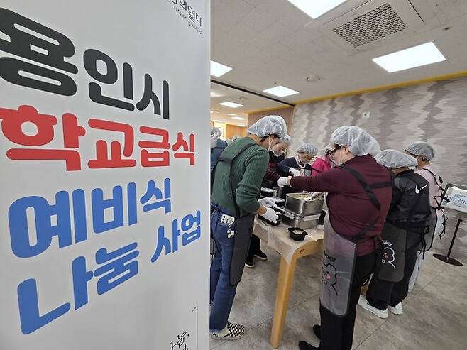 기흥노인복지관에서 자원봉사자들이 배송된 학교급식 예비식을 용기에 나눠 담고 있다.